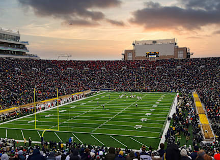 A football stadium is packed with fans watching a game.