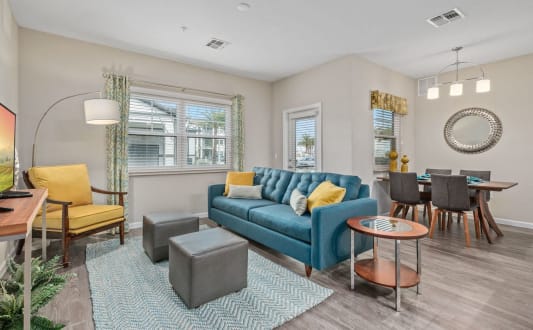 a living room with a blue couch and a dining room table