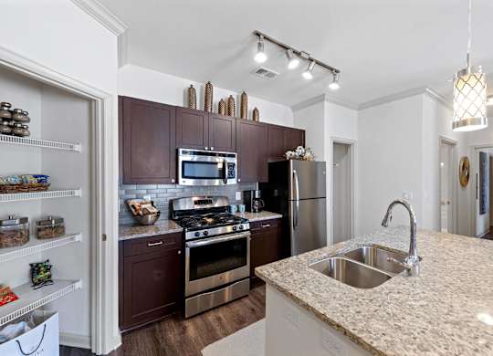 Kitchen with pantry and granite countertops at Atley on the Greenway Apartments in Ashburn VA