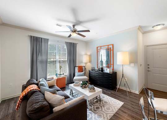 Living room with ceiling fan and large window at Atley on the Greenway Apartments in Ashburn VA