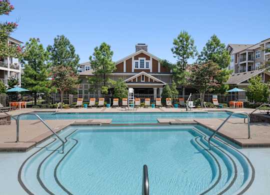 Large Swimming pool with deck chairs at Atley on the Greenway Apartments in Ashburn VA
