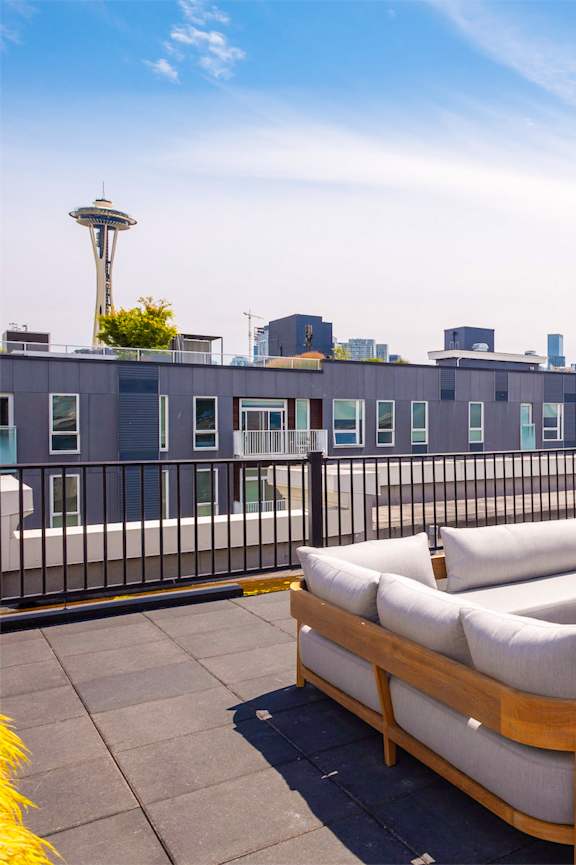 A Kettler foosball table is in the foreground of a rooftop patio with a view of the city.
