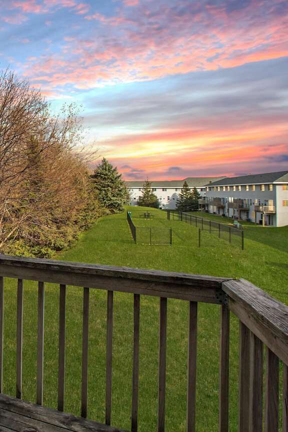 the view from the deck of a home with a sunset