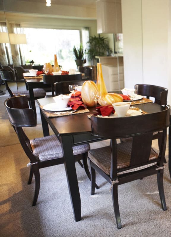 the kitchen and dining area of a home with a table and chairs