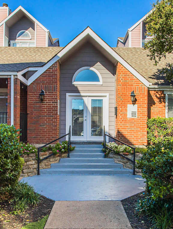 the front entrance to a brick house with a porch and stairs