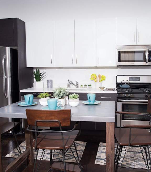 A modern kitchen with a table set for two.