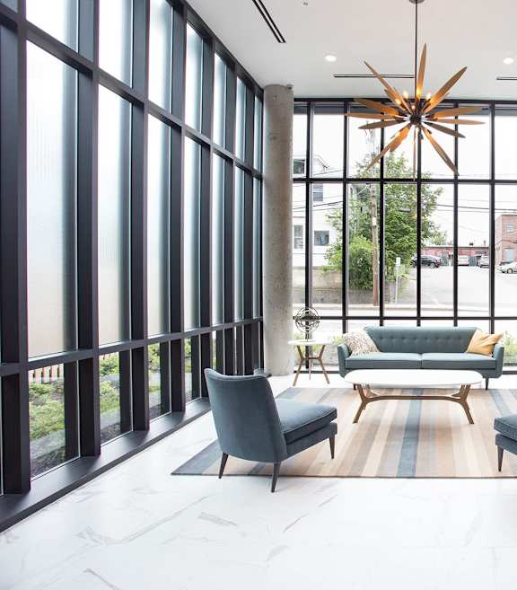 A modern living room with a large window and a starburst light fixture.