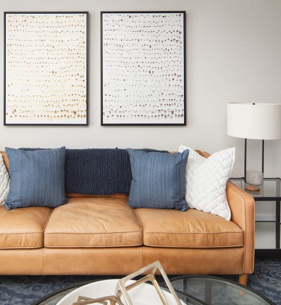 a living room with a couch table and chairs and a kitchen in the background