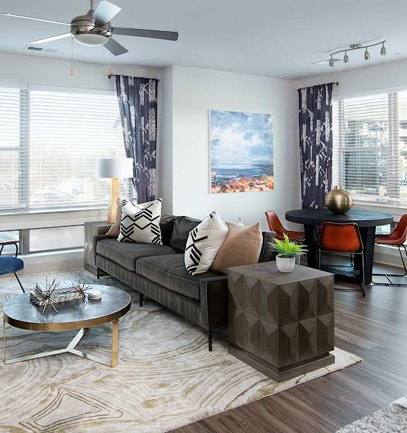 A living room with a grey sofa, a coffee table, and a painting on the wall. at Berewick Pointe Apartments , Charlotte, NC