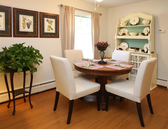 a dining room with a wooden table and white chairs