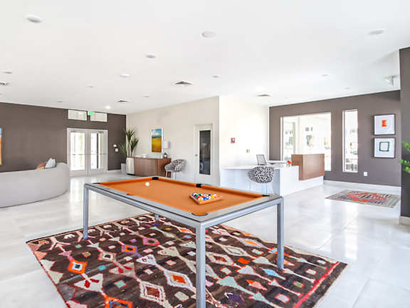 A billiard table in the middle of a room with a rug.
