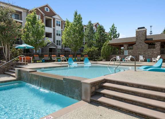 Swimming pool with waterfall feature at Atley on the Greenway Apartments in Ashburn VA
