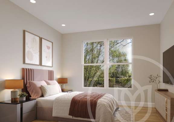 A bedroom with a large bed and a window overlooking a tree-filled landscape.