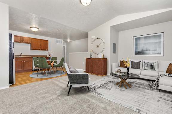 A living room with a grey rug and a white couch.