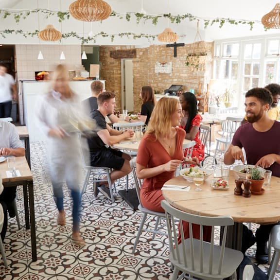 A group of people are sitting at tables in a restaurant.