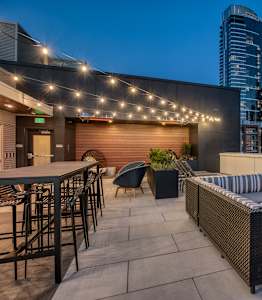 a rooftop patio with a city skyline at night at Orion, Washington, 98109