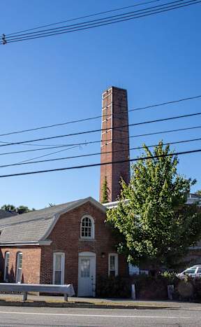 Historic brick building with tall chimney at Star Mill Lofts Apartments, Middleboro, 02370