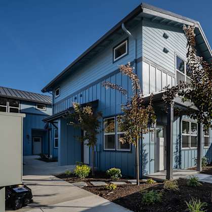 A blue house with a white door and windows.