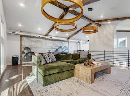 A living room with a green couch and a wooden coffee table.
