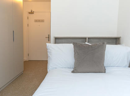 a bedroom with a bed with two pillows and a door