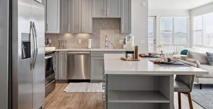 A modern kitchen with a large island and stainless steel appliances.