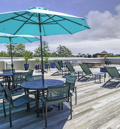 A patio with a table and chairs and a blue umbrella.