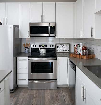 a modern kitchen with stainless steel appliances and white cabinets