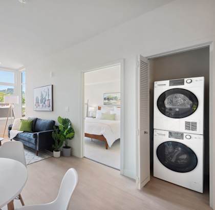 a living room with a washer and dryer combo and a dining table with white chairs at Second & B Street, San Rafael, 94901