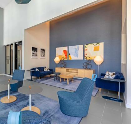 A modern living room with blue chairs and a grey couch.