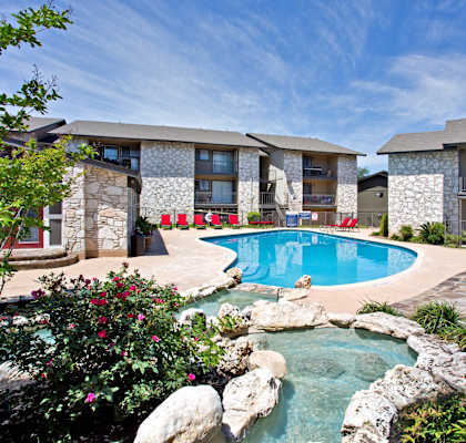 a swimming pool with a pool house and a resort style pool