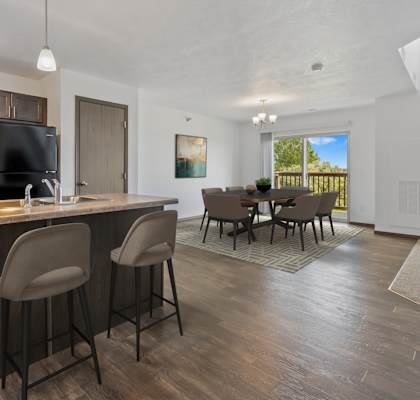 A kitchen with a bar area and a dining table.