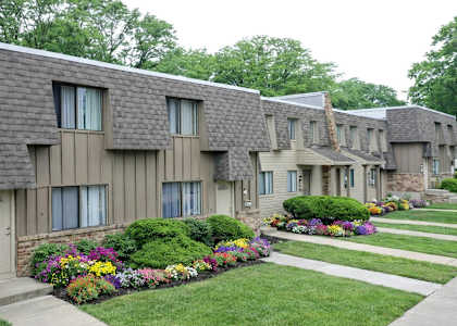 Apartment complex with a well-maintained garden in front.