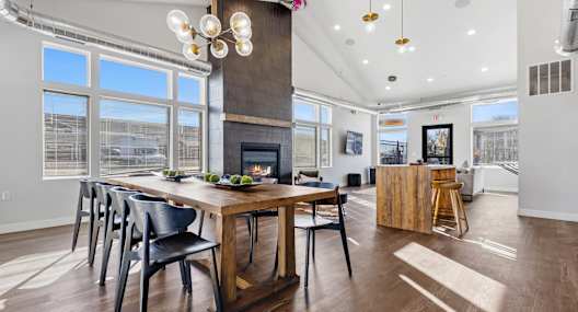 A modern dining room with a wooden table and chairs.