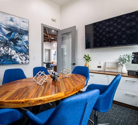 Stadium 700 conference room with a wooden table and blue chairs