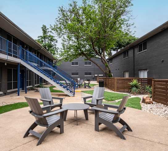 Stadium 700 patio with four chairs and a table outside of a building