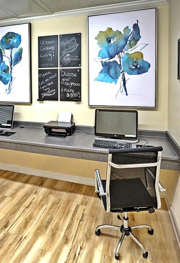 A room with a desk and chairs and a chalkboard on the wall.