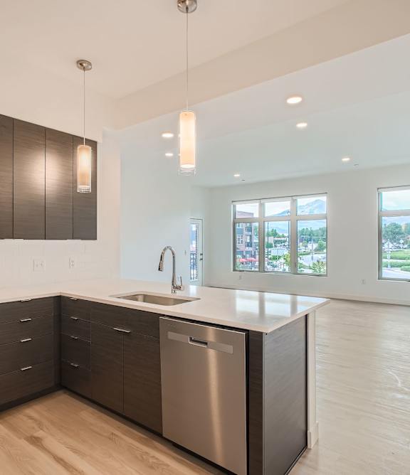 a kitchen with a large center island with a stainless steel dishwasher and a stove top oven