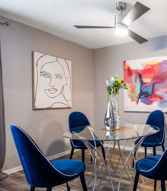 Stadium 700 dining room with blue chairs and a glass table