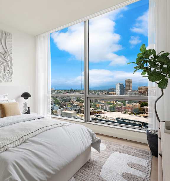 an apartment bedroom with a bed and a large window