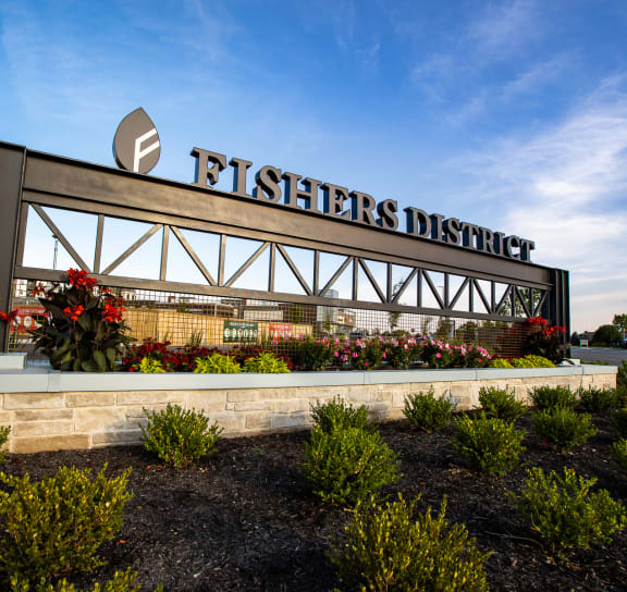 a sign for Fishers District with plants in front of it at Slate at Fishers District, Fishers, IN, 46037