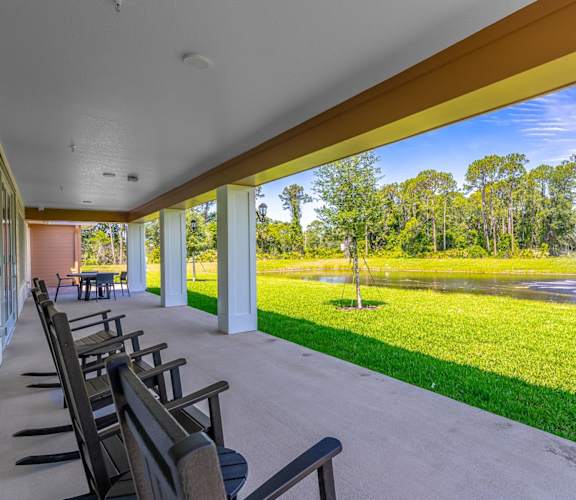 A row of wooden benches are lined up on a concrete patio.