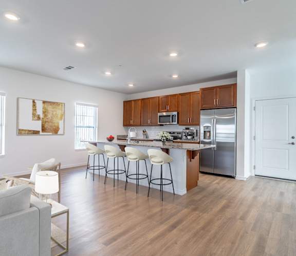 A modern kitchen with wooden cabinets and a white island.