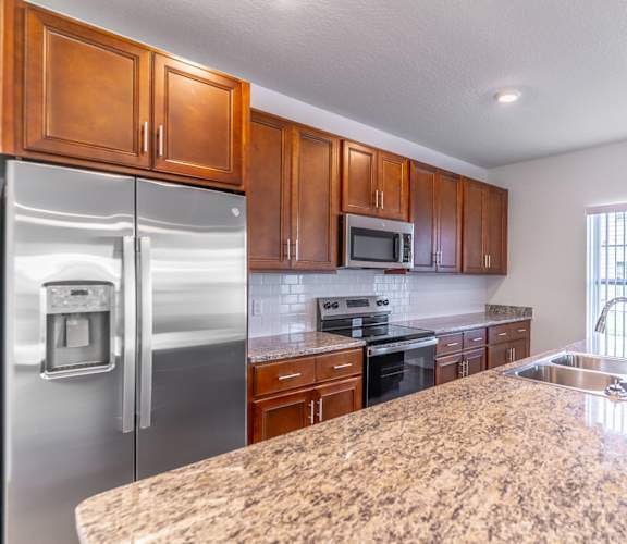 A kitchen with granite countertops and stainless steel appliances.
