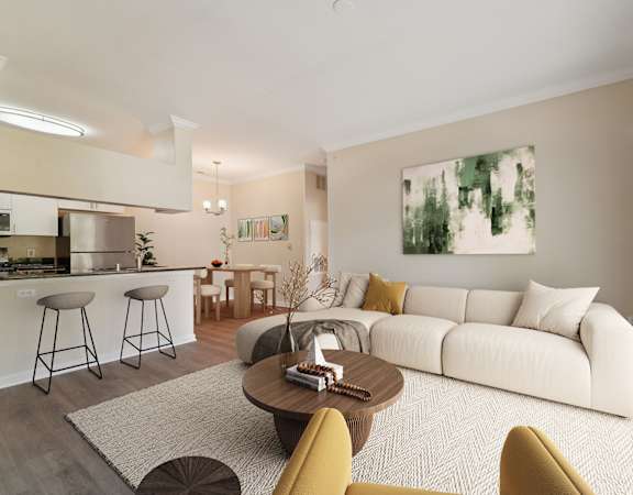 A modern living room with a white sofa, a coffee table, and a painting on the wall.