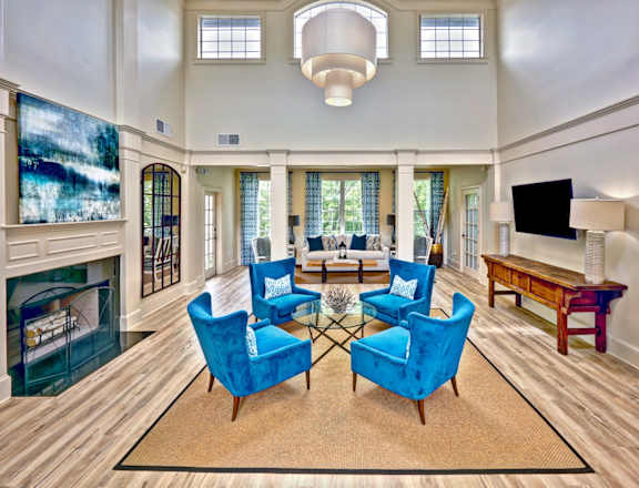 a living room with blue chairs and a fireplace