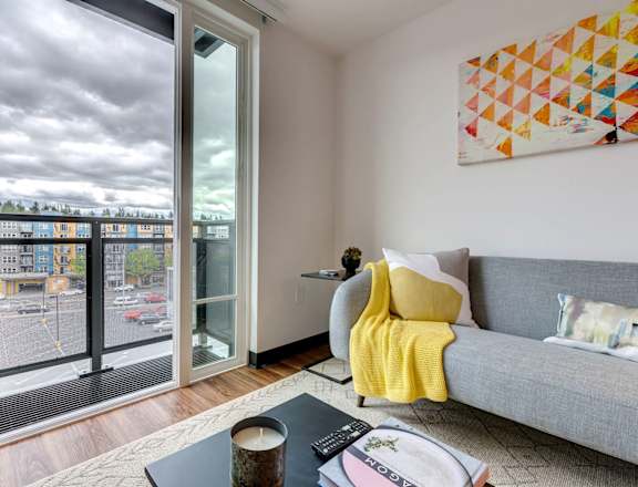 a living room with a large window and a gray couch