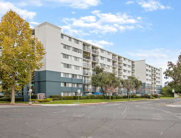 avenue two exterior of apartment building with green trees and grass at Avenue Two Apartments, Redwood City, CA