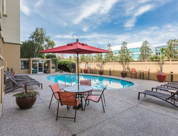avenue two resident pool with lounge chairs and patio seating at Avenue Two Apartments, Redwood City, CA
