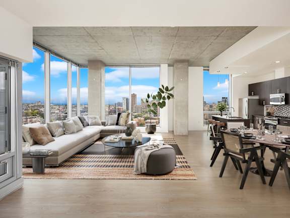 a living room with a couch and a table in front of windows