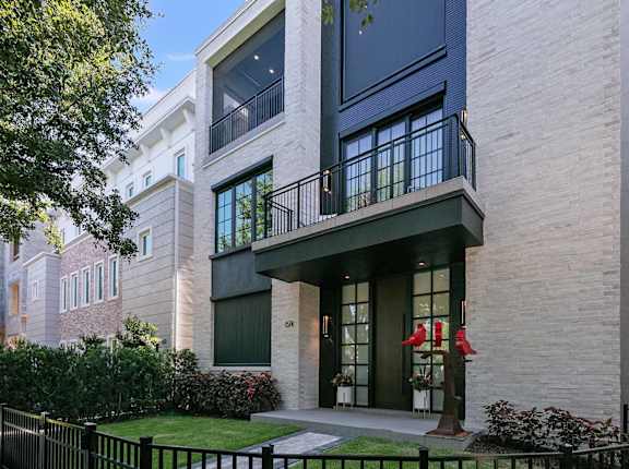 A modern house with a black gate and a balcony.